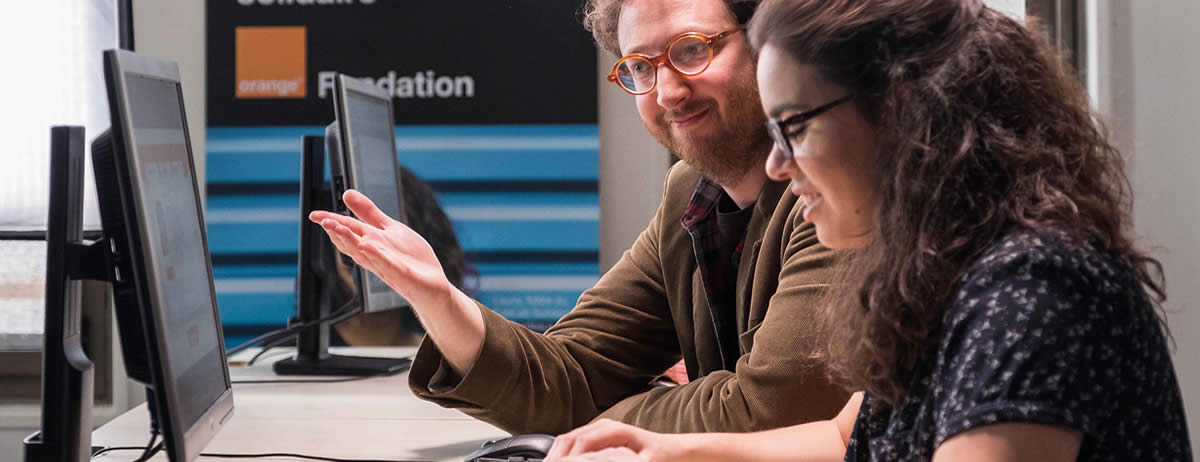 Une femme et un homme face à un écran d'ordinateur